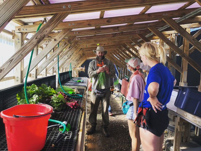 Students listening to an instructor at the sustainable student farm