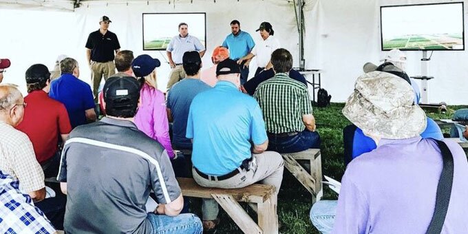Group of people sitting in a tent listening to a speaker talk