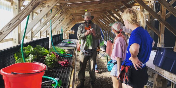 Students listening to an instructor at the sustainable student farm